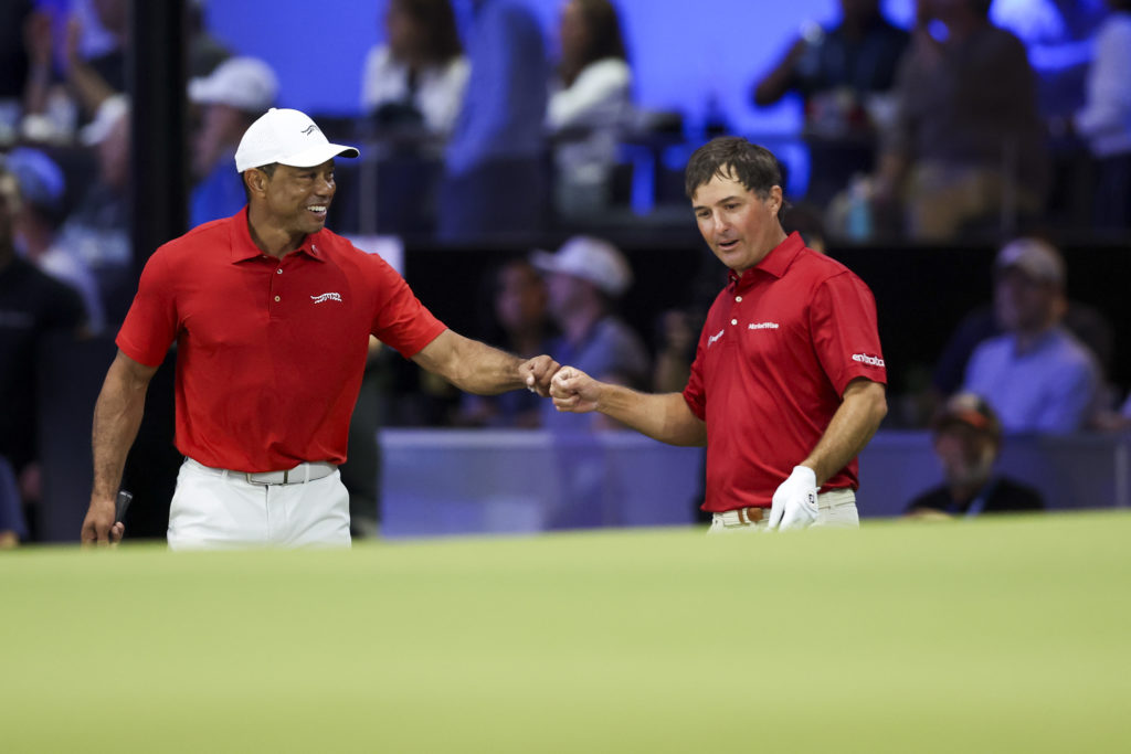 Tiger Woods fist bumps Kevin Kisner during a TGL match