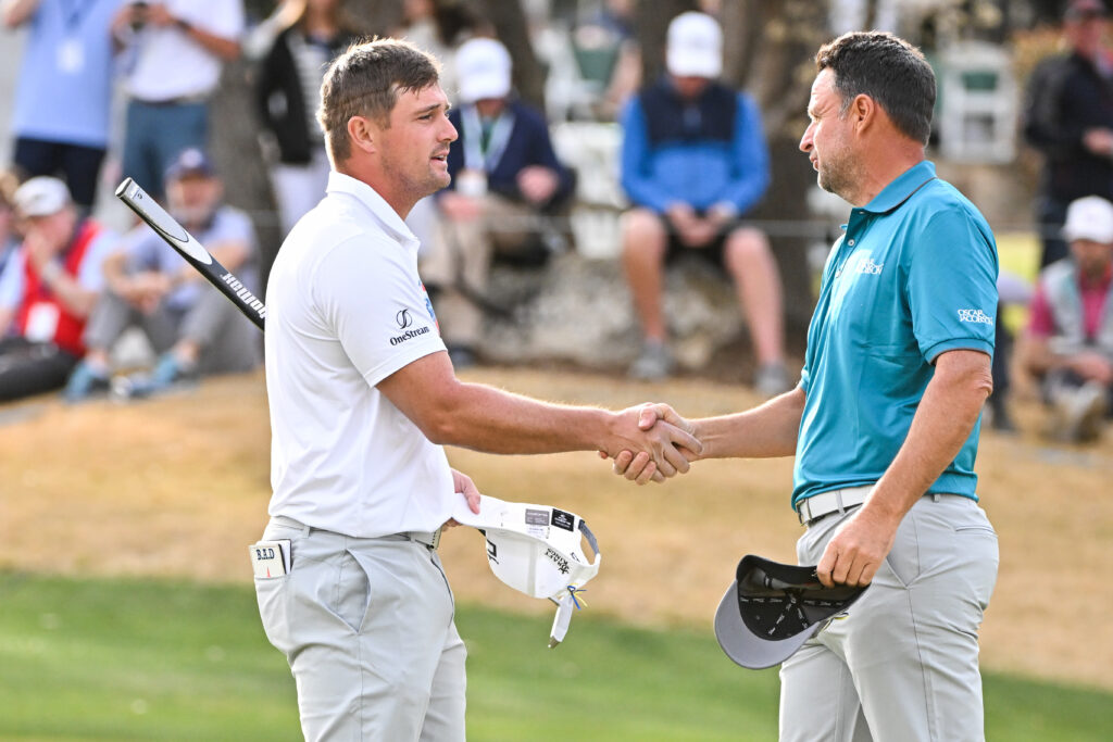Bryson DeChambeau and Richard Bland shake hands at the World Golf Championships in 2022