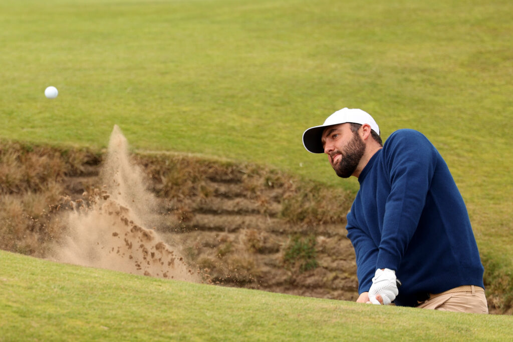 Scottie Scheffler playing out of a bunker at The Open Championship