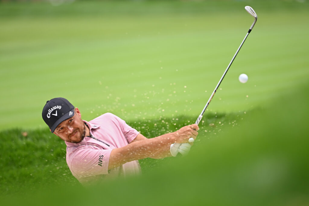 Xander Schauffele practices a bunker shot in a practice round at the US Open