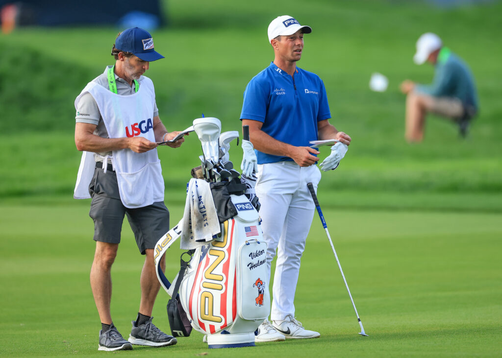 Viktor Hovland prepares to hit his approach on the 18th green during the third round of the US Open