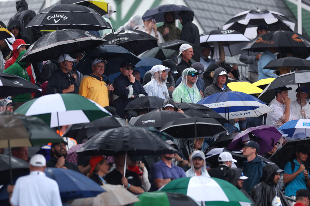 Galleries at Oakmont take cover from the rain during the final round of the US Open