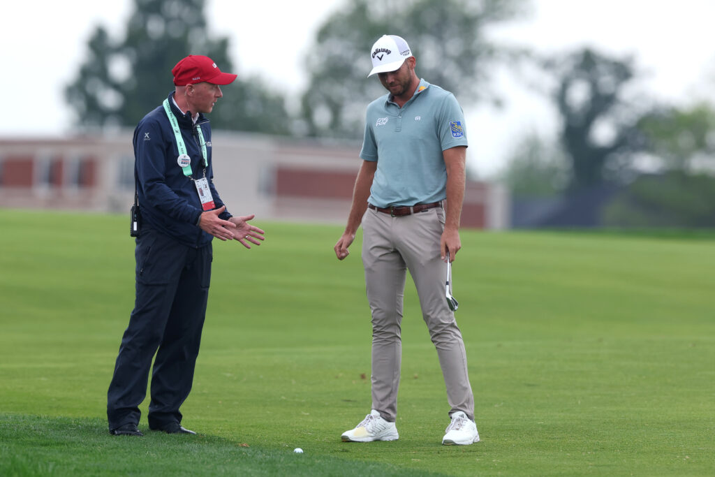 Sam Burns talks to a rules offical at the US Open on the 15th hole