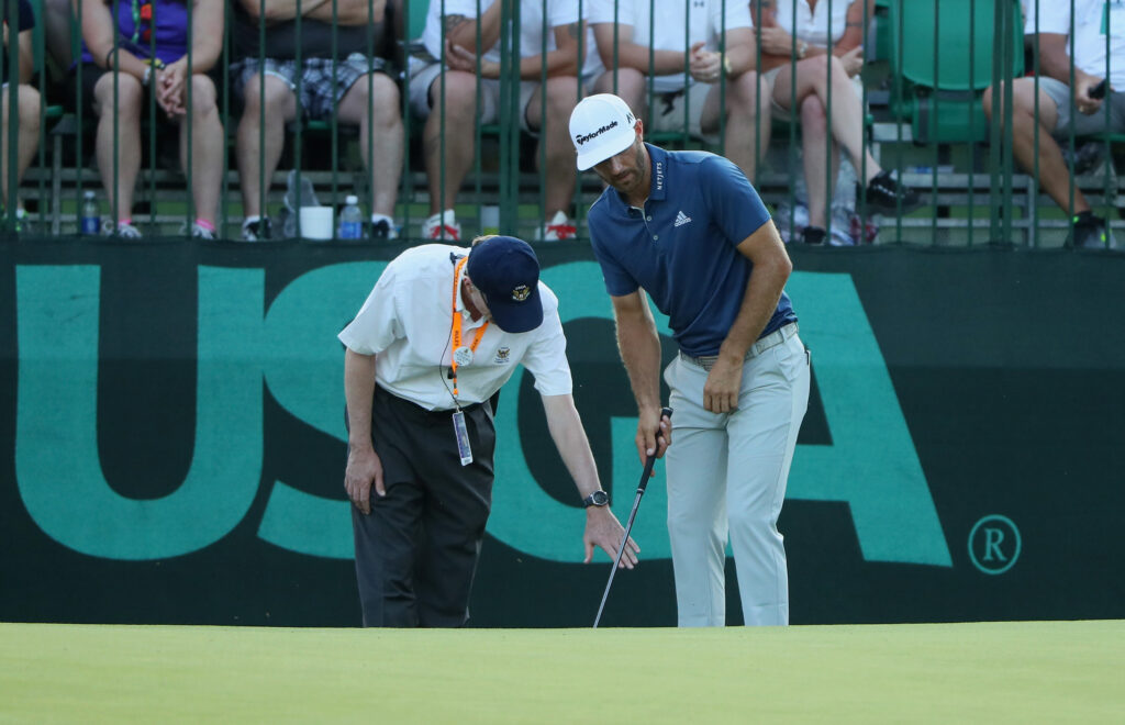 Dustin Johnson calls in a rules official during the final round of the 2016 US Open