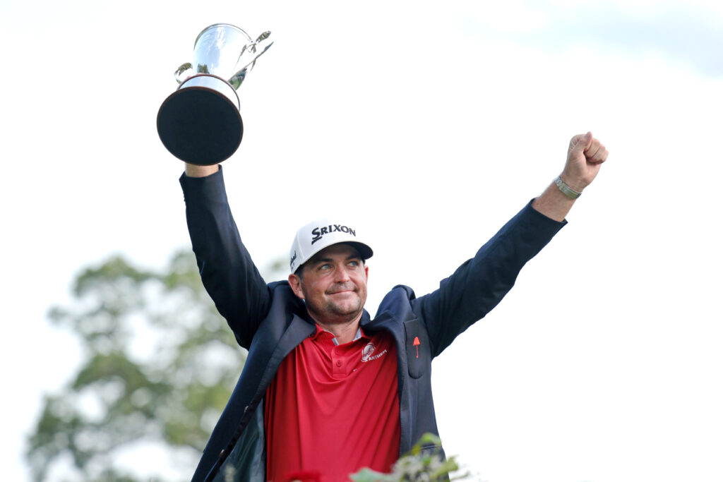 Keegan Bradley lifts the Travelers Championship trophy aloft