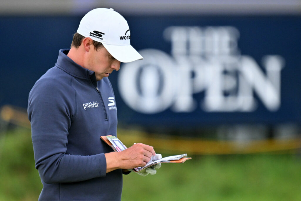Matthew Fitzpatrick checks his yardage book during the second round of The Open Championship at Royal Portrush