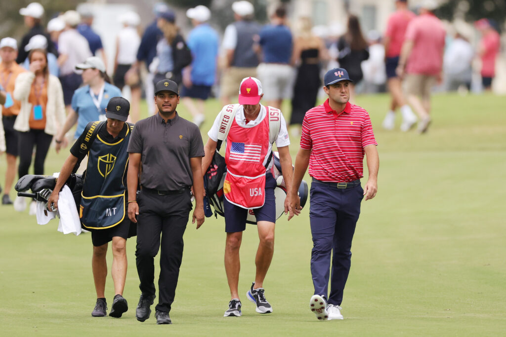 Sebastian Munoz and Scottie Scheffler walk down the fairway during their singles match at the 2022 Presidents Cup