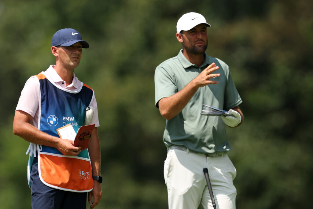 Scottie Scheffler discusses an iron shot with his caddie during round two of the BMW Championship