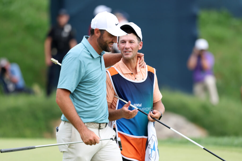 Scottie Scheffler of the United States celebrates with stand-in caddie Michael Cromie on the 18th green after winning the BMW Championship