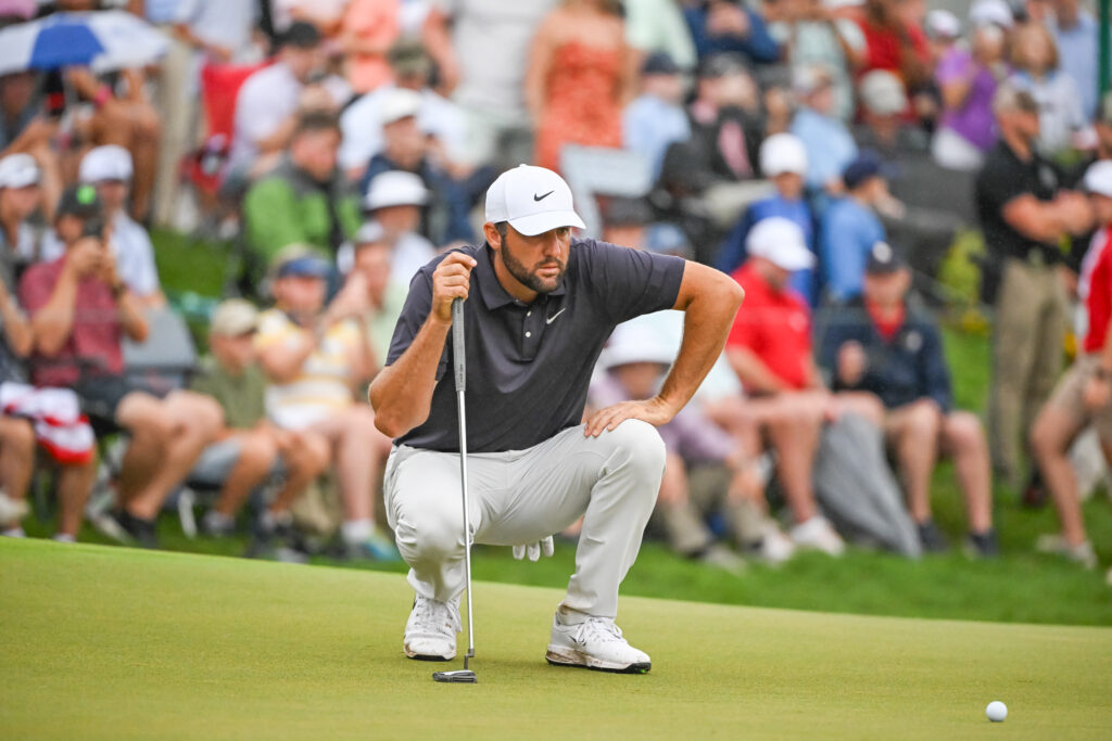 Scottie Scheffler lining up his putt on the eighteenth green during the third round of the Tour Championship at East Lake