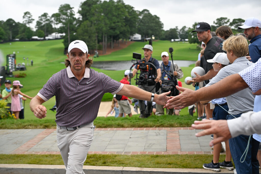 Tommy Fleetwood high fives fans while walking off the 18th green during the third round of the TOUR Championship at East Lake
