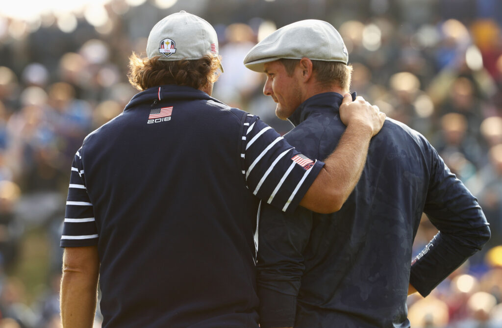 Phil Mickelson talks with Bryson DeChambeau during their match on Friday morning at the 2018 Ryder Cup