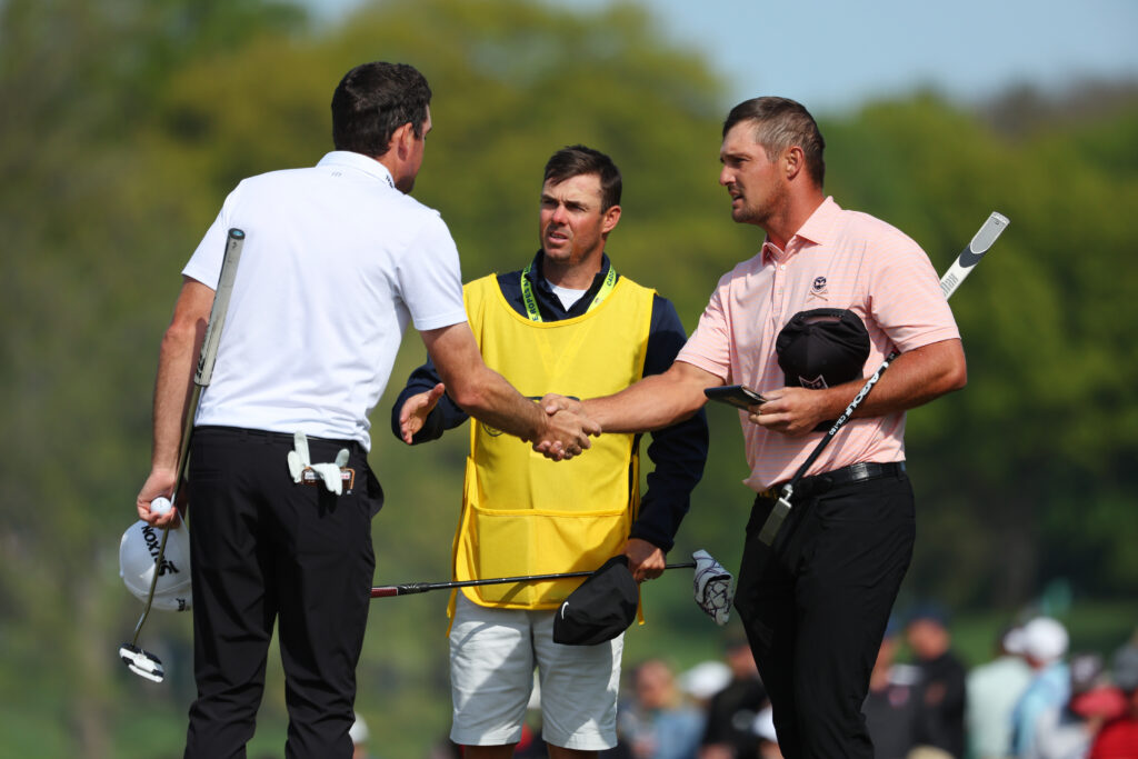 Keegan Bradley and Bryson DeChambeau shake hands on the ninth green during the first round of the 2023 PGA Championship at Oak Hill Country Club