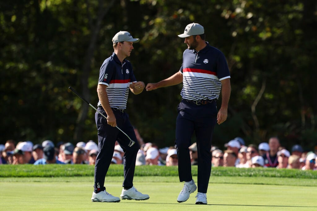 Russell Henley and Scottie Scheffler of Team United States react on the 12th hole green during the 2025 Ryder Cup