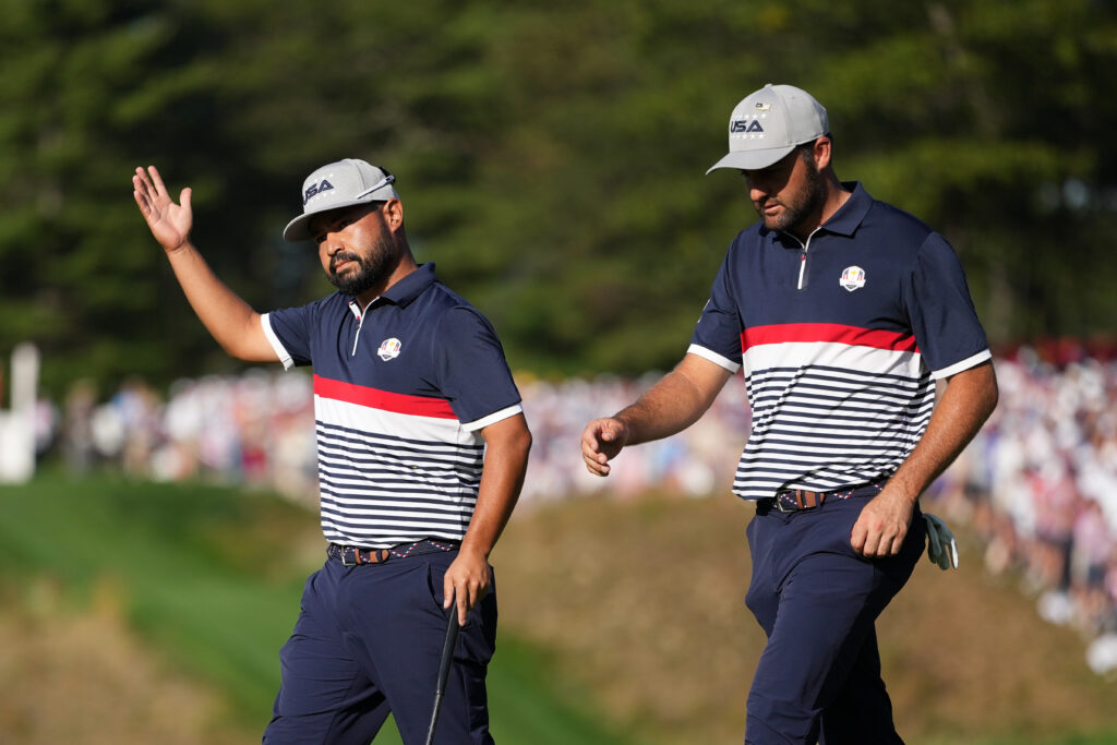 J.J. Spaun an Scottie Scheffler of Team United States walk off the green at the 2025 Ryder Cup.