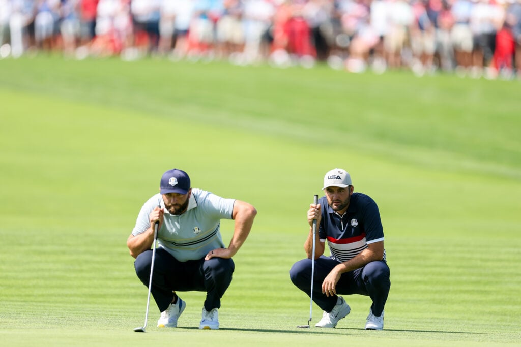 Jon Rahm and Scottie Scheffler line up their putts during the Friday afternoon session at the Ryder Cup