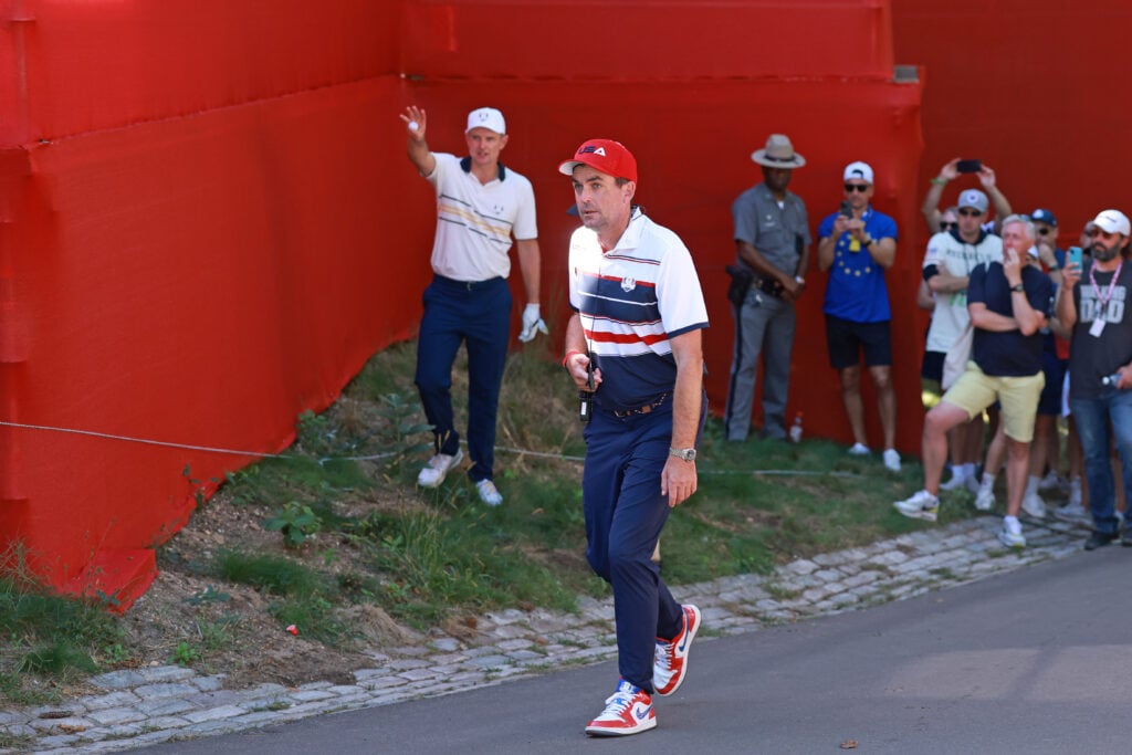 Justin Rose and Keegan Bradley speak on the 13th hole during the Sunday singles at the Ryder Cup