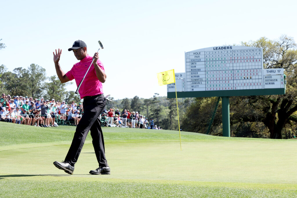 Tiger Woods waves to the crowd while walking off the 18th green after finishing his round during the first round of the Masters in 2022