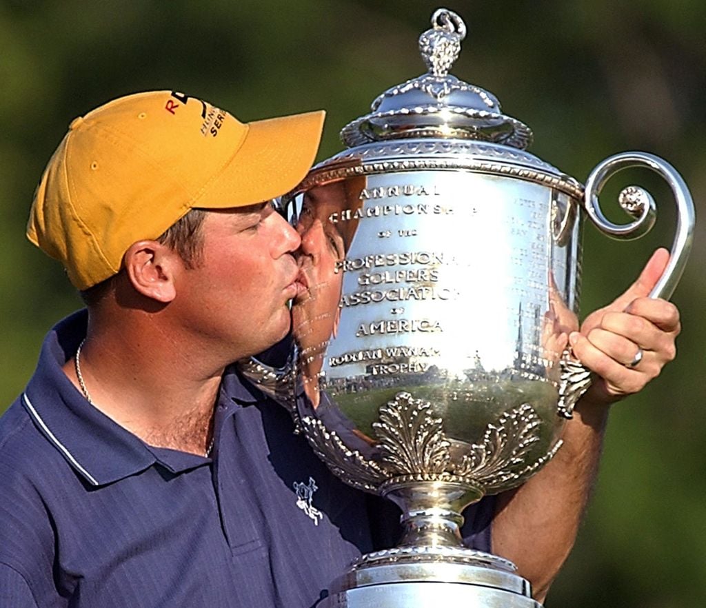 Rich Beem (R) of the US kisses the Wanamaker trophy after he won the 2002 PGA championship