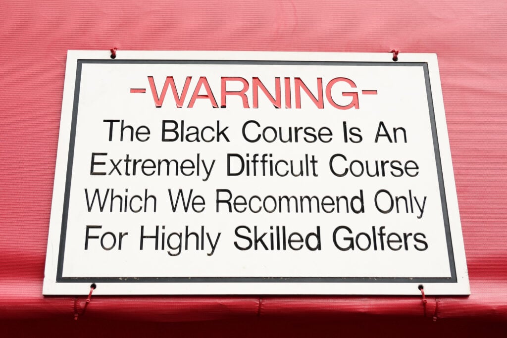 A detailed view of a warning sign during a practice round prior to the Ryder Cup 2025 at Black Course at Bethpage