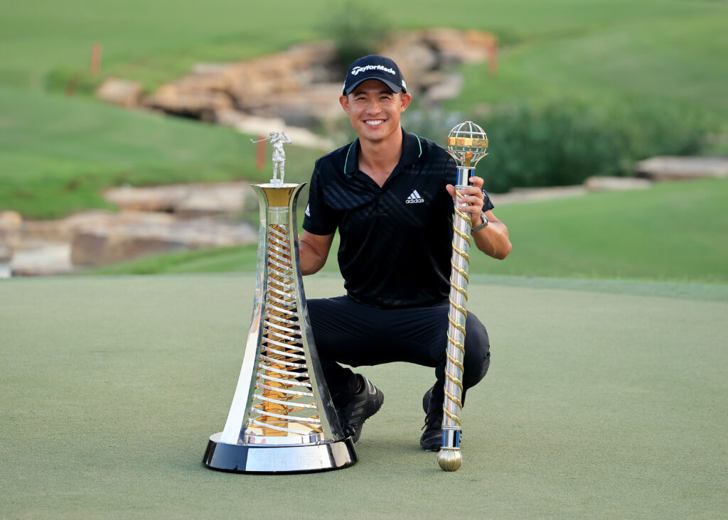 Collin Morikawa of The United States poses with the Race to Dubai trophy (L) and the DP World Tour Championship trophy (R)