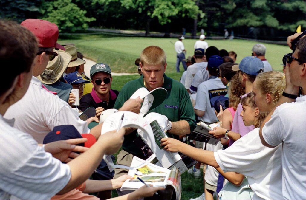 John Daly signs autographs during a practice round for the US Open at Oakmont