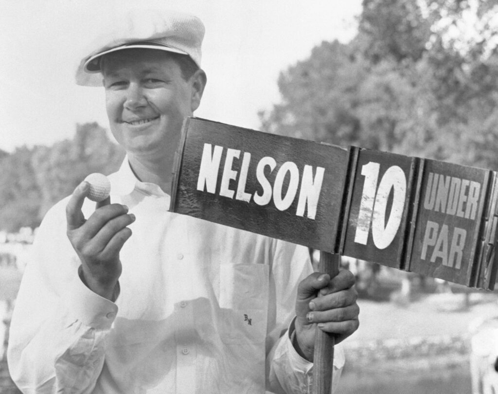 Byron Nelson holding a golf ball next to a scoreboard that shows he was 10-under par