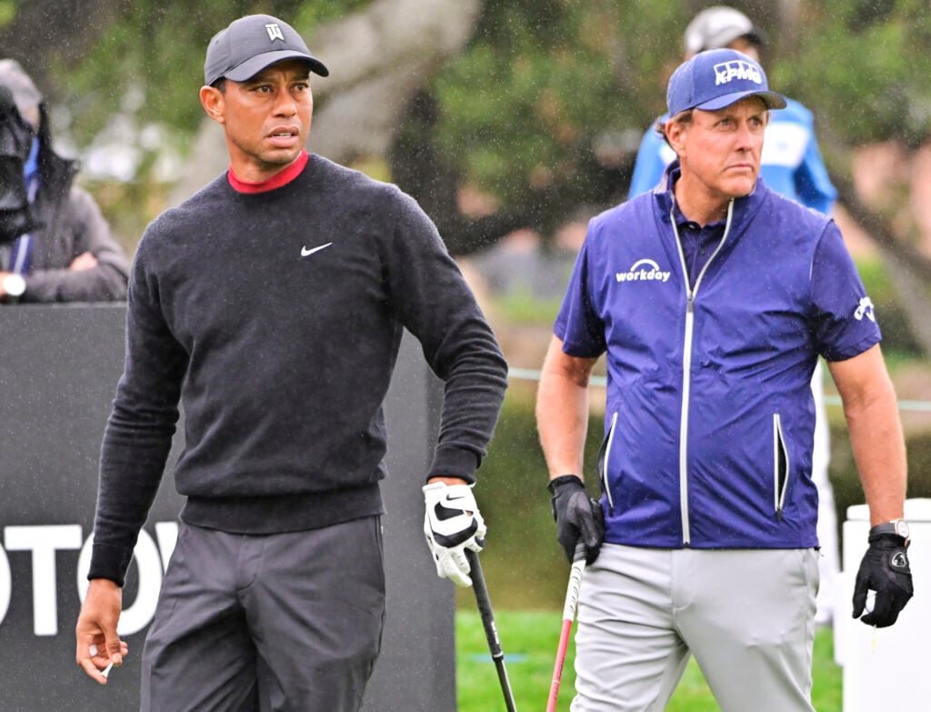 Tiger Woods watches his tee shot on the 10th hole while Phil Mickelson gets ready to hit during the final round of the ZOZO Championship