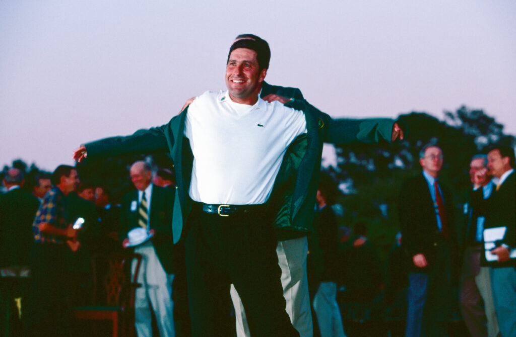 Jose Maria Olazabal being given the green jacket by the Mark O'Meara at the Masters Golf at The Augusta National