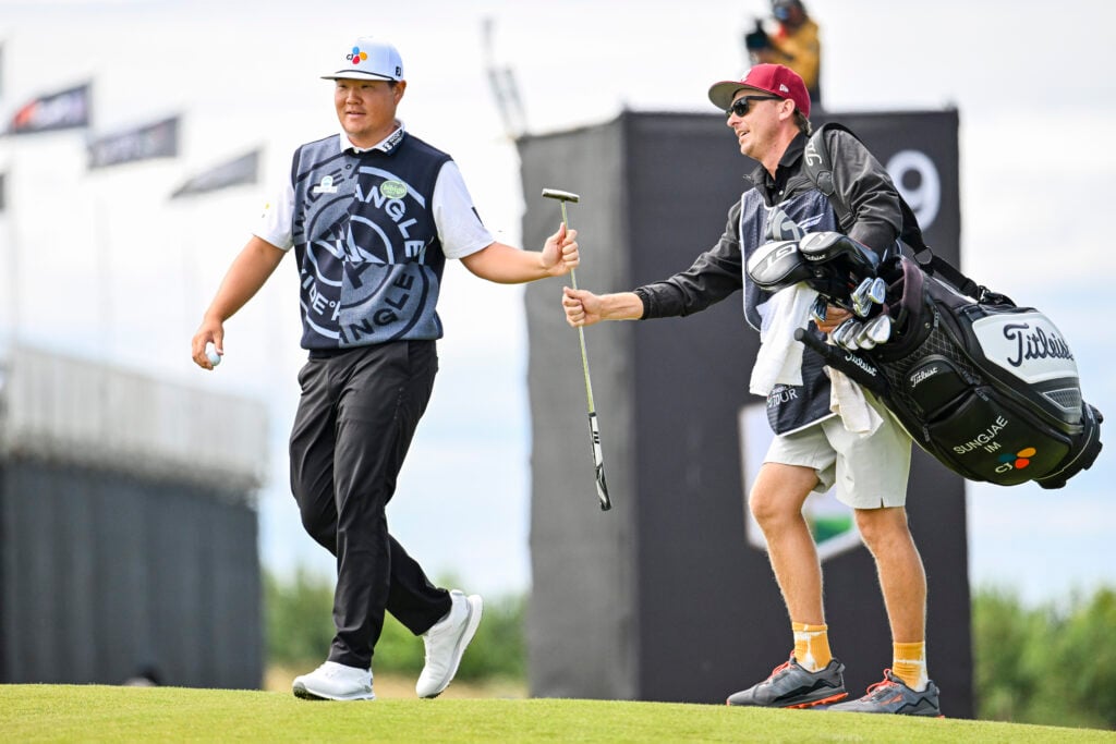 Sungjae Im hands his putter to his caddie during the Scottish Open