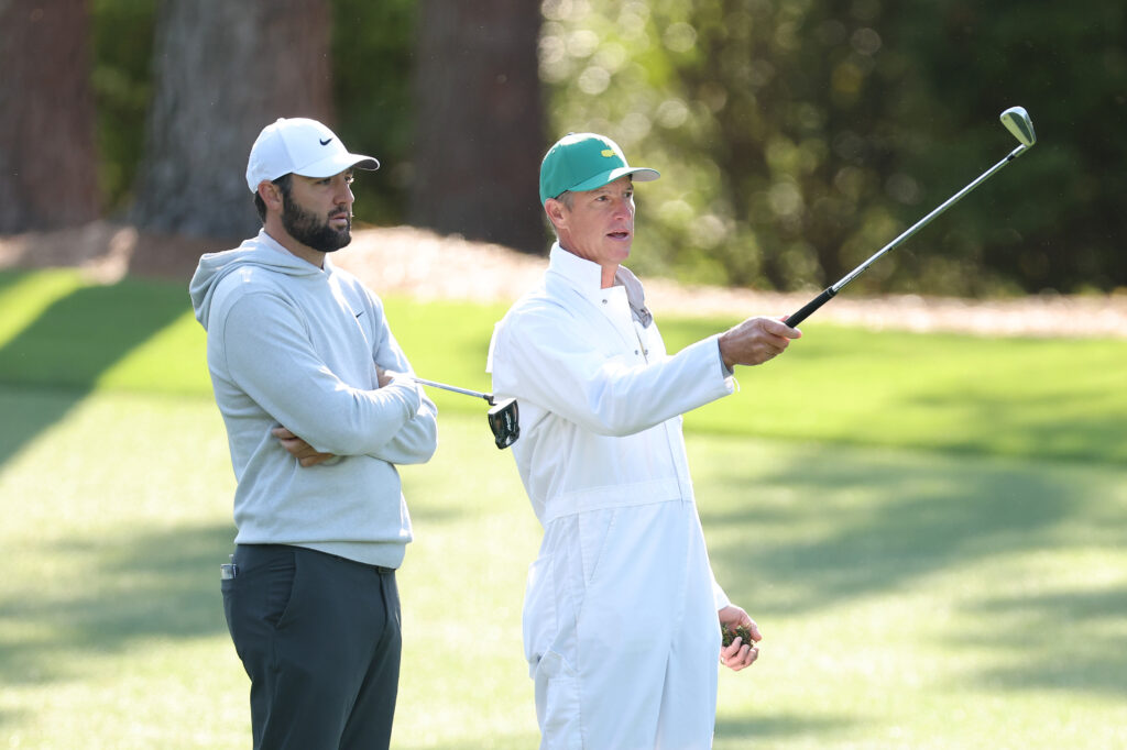 Scottie Scheffler and Ted Scott speak during a practice round ahead of the 2025 Masters