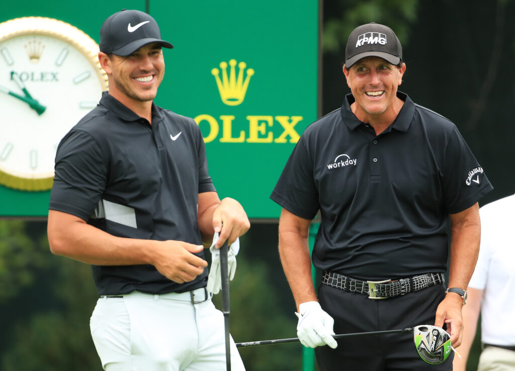 Brooks Koepka of the United States and Phil Mickelson of the United States talk on the tenth tee during the final round of the BMW Championship 2019 at Medinah Country Club