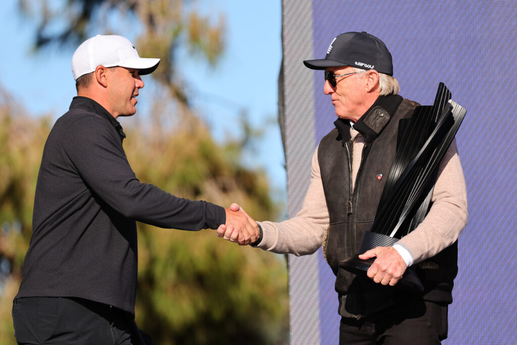 Greg Norman presents Brooks Koepka with a trophy after the LIV Golf Invitational event at Las Vegas