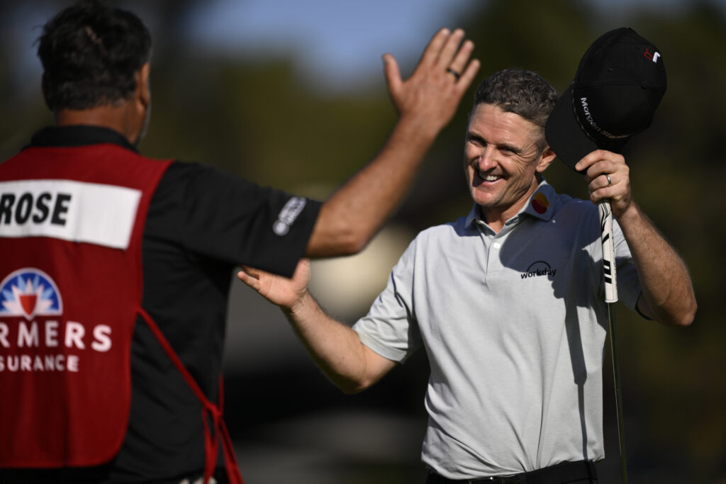 Justin Rose celebrates with his caddie after winning the Farmers Insurance Open
