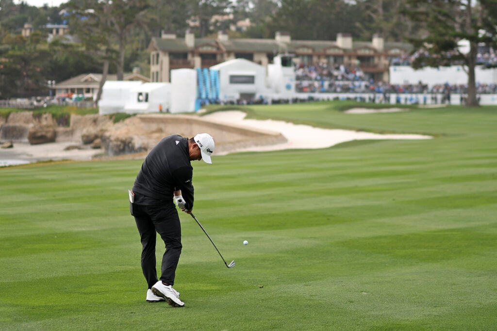 Collin Morikawa hits his second shot into the 18th green during the final round of the AT&T Pebble Beach Pro-Am 2026.