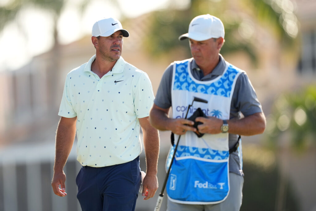 Brooks Koepka looks on from the 16th green alongside his caddie during the second round of the Cognizant Classic