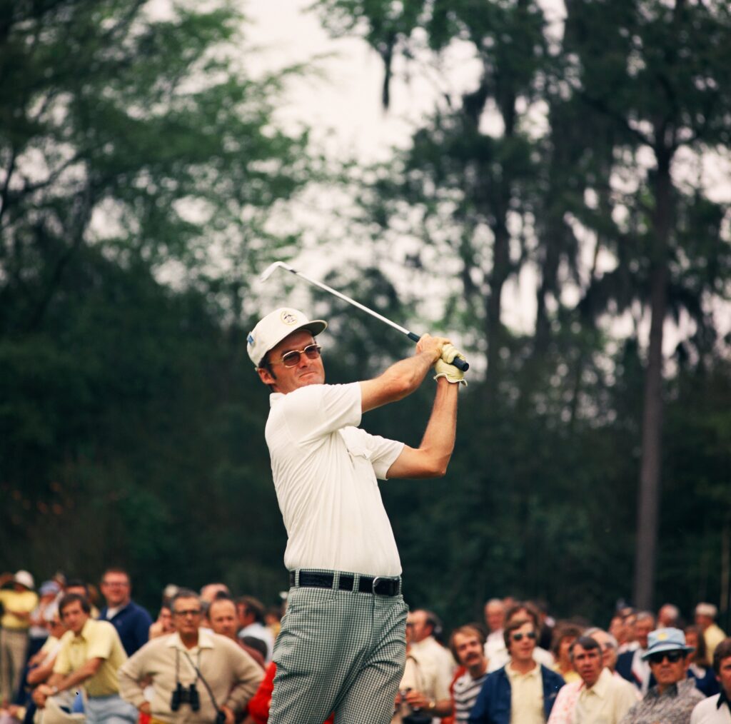 Mac McLendon watches his shot from the finish position in front of a small gallery during the 1975 Masters Tournament at Augusta National Golf Club