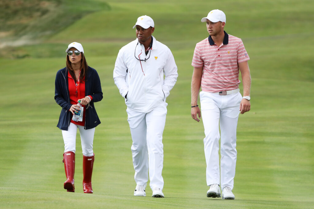 Daniel Berger of the U.S. Team, Captain's assistant Tiger Woods of the U.S. Team and Erica Herman walk during Friday four-ball matches of the Presidents Cup at Liberty National
